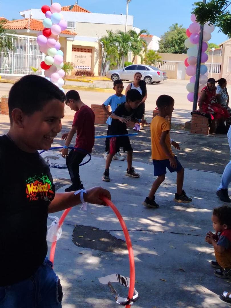 Niños jugando con aros en una jornada recreativa del Día del Niño