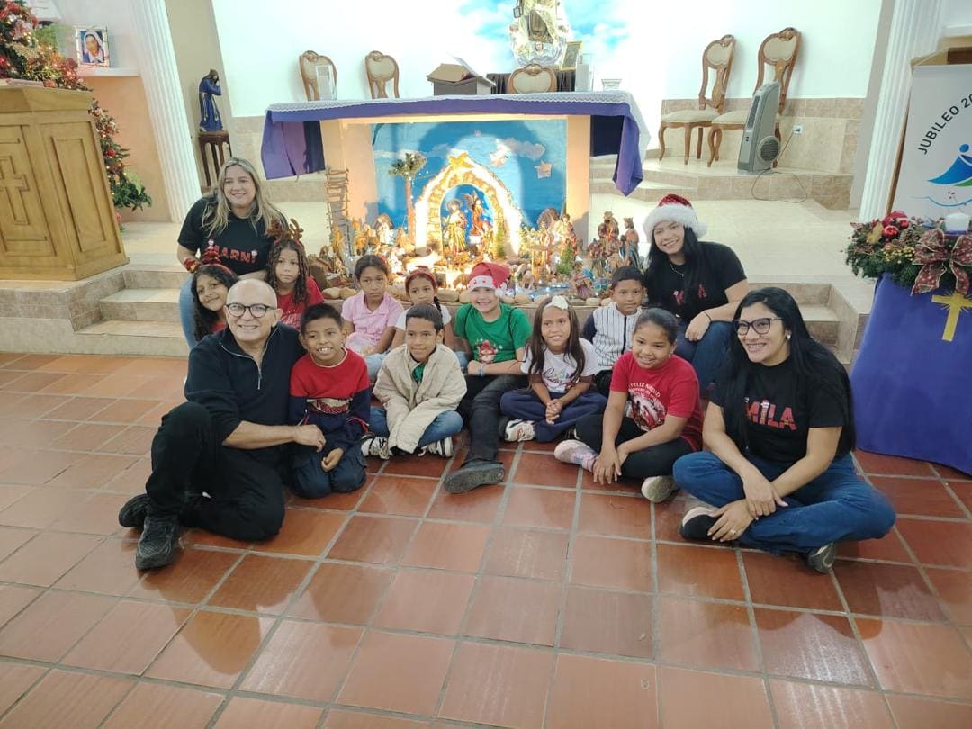 Celebración navideña con niños de la comunidad frente al pesebre
