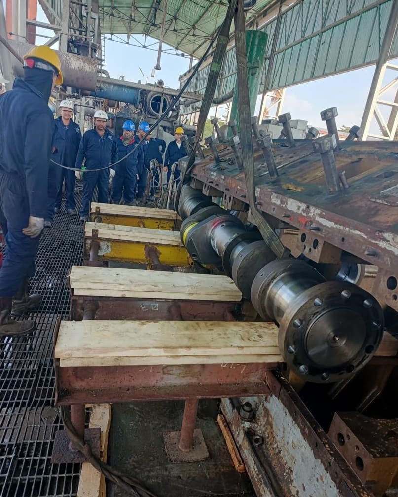 Cigüeñal asentado sobre camas de madera con cuadrilla al fondo