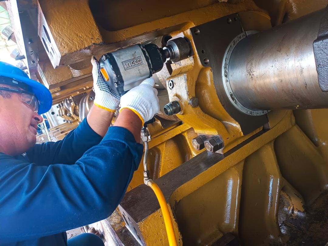 Técnico con llave de impacto sobre bancada amarilla