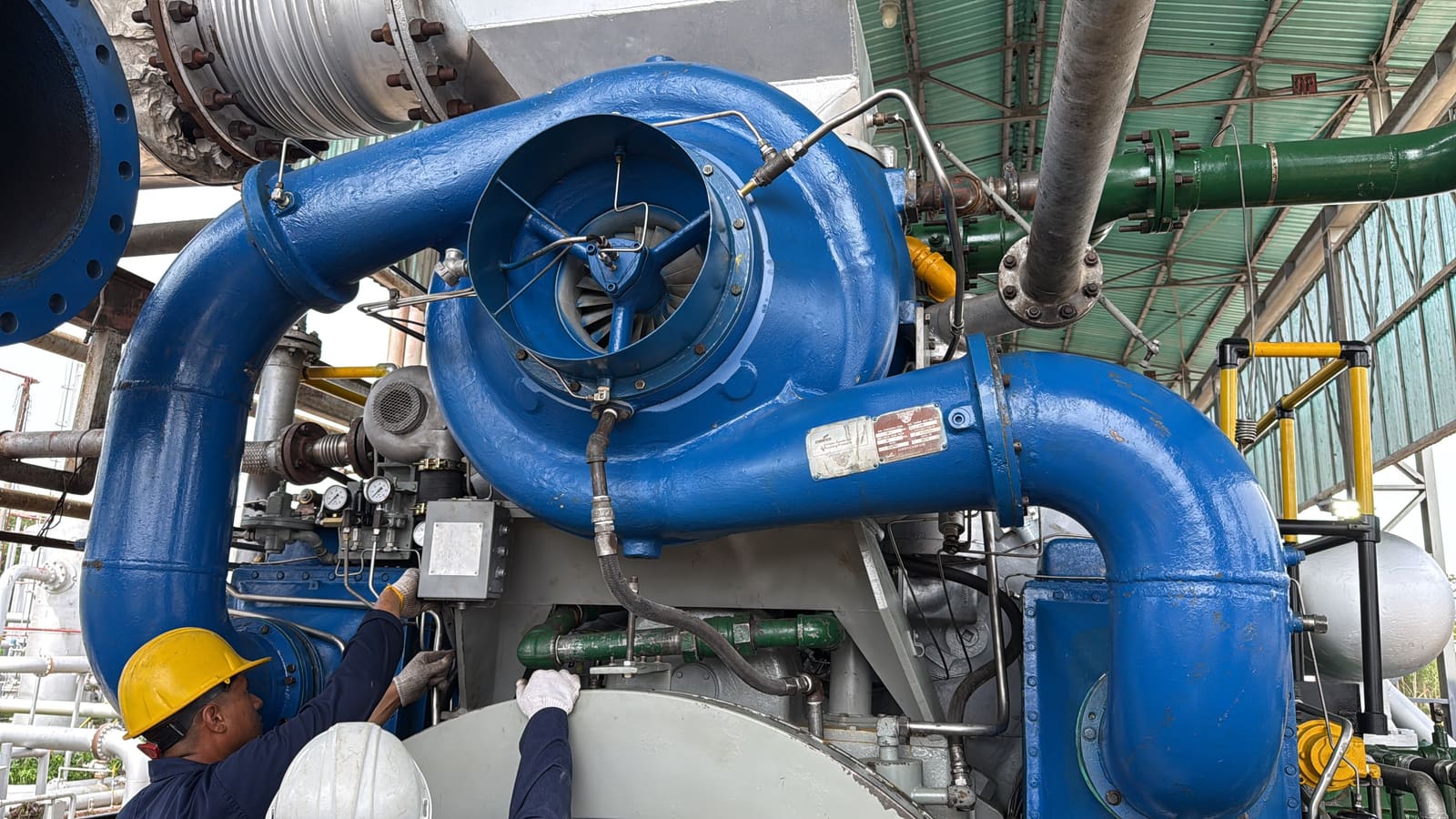 Turbocargador azul Cooper-Bessemer con dos técnicos trabajando
