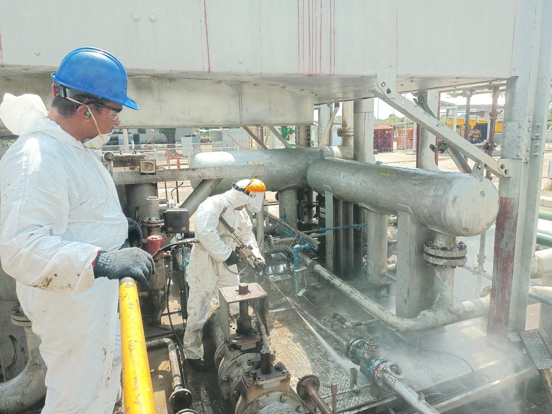 Supervisor observando hidrolavado de skid en planta operativa