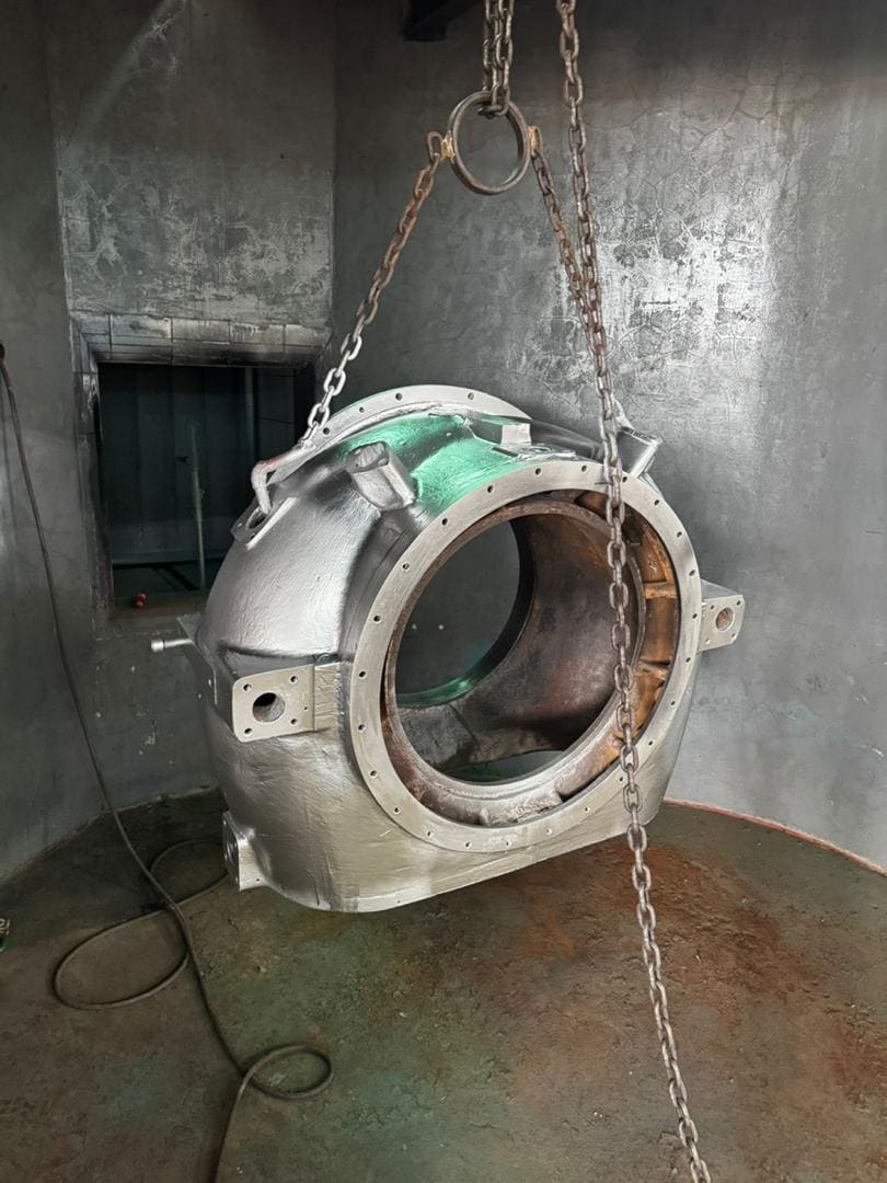 Carcasa suspendida con cadenas en cabina de granallado y pintura